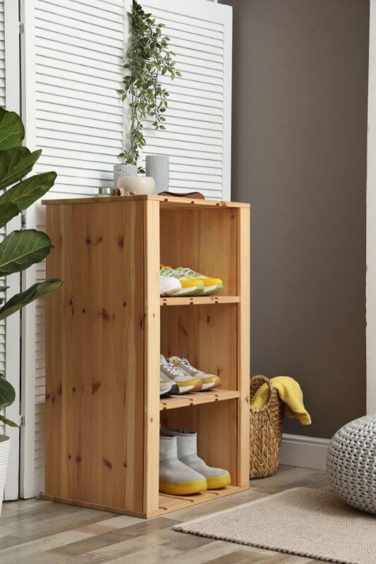 chaussures rangées dans un meuble en bois pour illustrer le désencombrement de l'entrée
